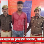 एक पुलिस अधिकारी चोरी की पल्सर मोटरसाइकिल के पास खड़े हैं, जिसके बगल में गिरफ्तार बाइक चोर कृष्णा डोम खड़ा है।