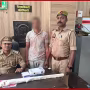 वाराणसी में फायरिंग मामले में गिरफ्तार आरोपी को पुलिस हिरासत में दिखाती तस्वीर