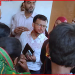 महिलाओं द्वारा सहायक अभियंता को घेरा हुआ प्रदर्शन करते हुए