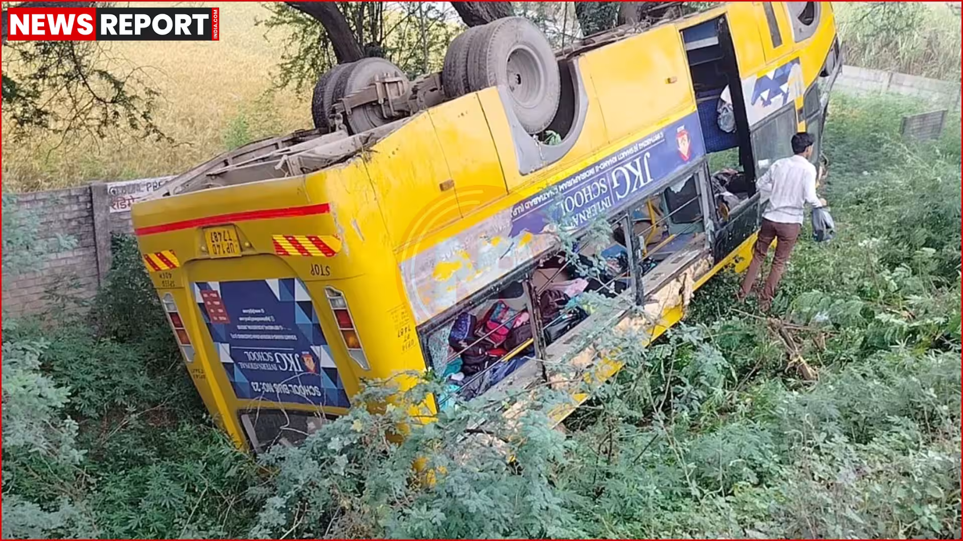 बस दुर्घटना का दृश्य जिसमें एक स्कूल बस खाई में गिरी हुई है और लोग बचाव कार्य में लगे हैं।