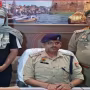 पुलिस हिरासत में शुभम राय, उसके हाथ में पिस्टल पकड़े पुलिस अधिकारी