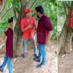 एक युवक दूसरे युवक को पिस्टल दिखाकर धमकाते और अपमानित करते हुए