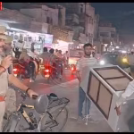 पुलिसकर्मी रामनगर में अतिक्रमण हटाते हुए, सड़क पर खड़े ठेले और वाहनों को हटाते हुए