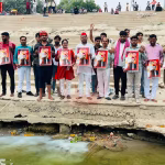 वाराणसी में मां गंगा का दूध से अभिषेक करते समाजवादी कार्यकर्ता और दूध वितरण