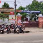 राधा किशोरी राजकीय बालिका इंटर कॉलेज की इमारत, जिस पर पीएम श्री विद्यालय का बोर्ड लगा हो, छात्राएं और शिक्षक खड़े हों।