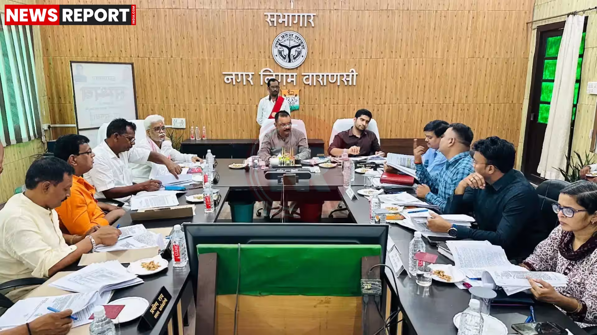 वाराणसी नगर निगम की डिजिटल सेवाओं को दर्शाते हुए एक हेल्पलाइन नंबर और शहर का दृश्य