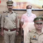 पुलिस एक व्यक्ति को हथकड़ी लगाए हुए