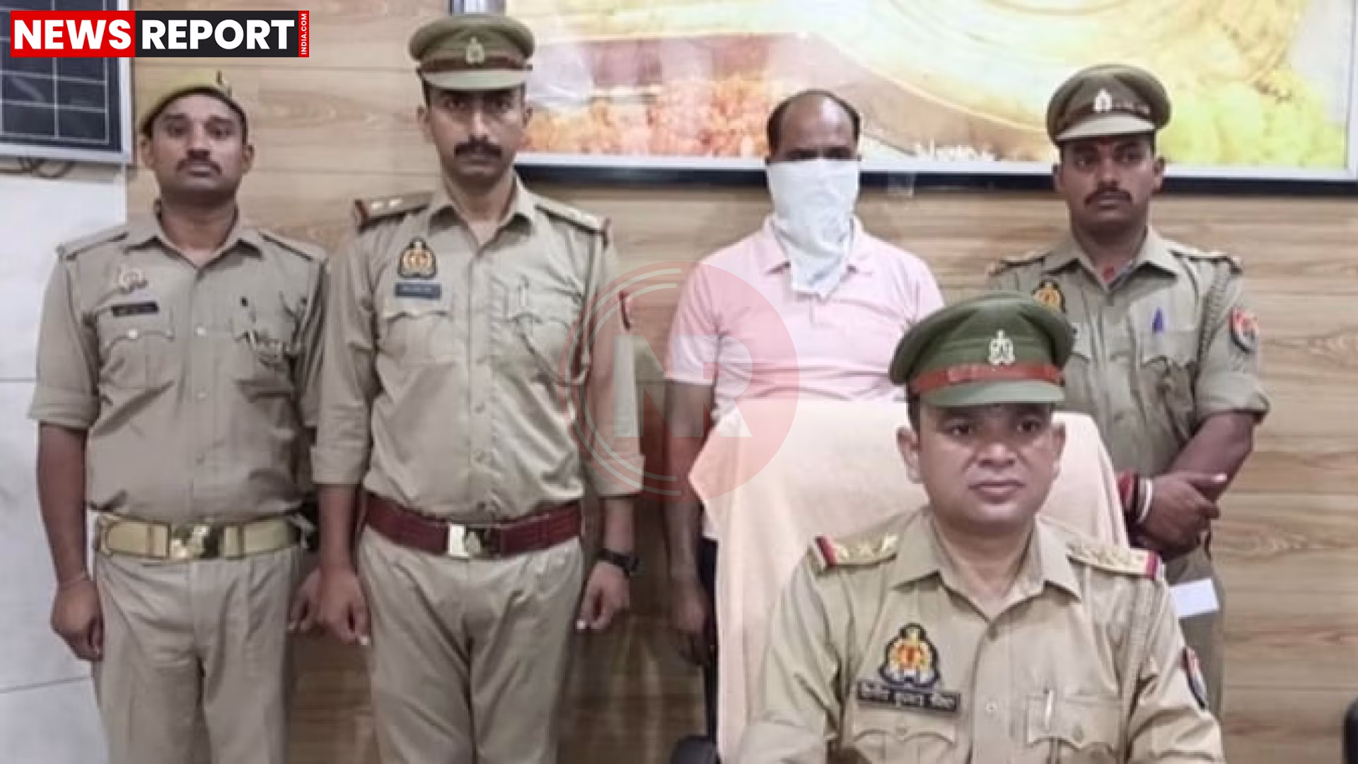 पुलिस एक व्यक्ति को हथकड़ी लगाए हुए
