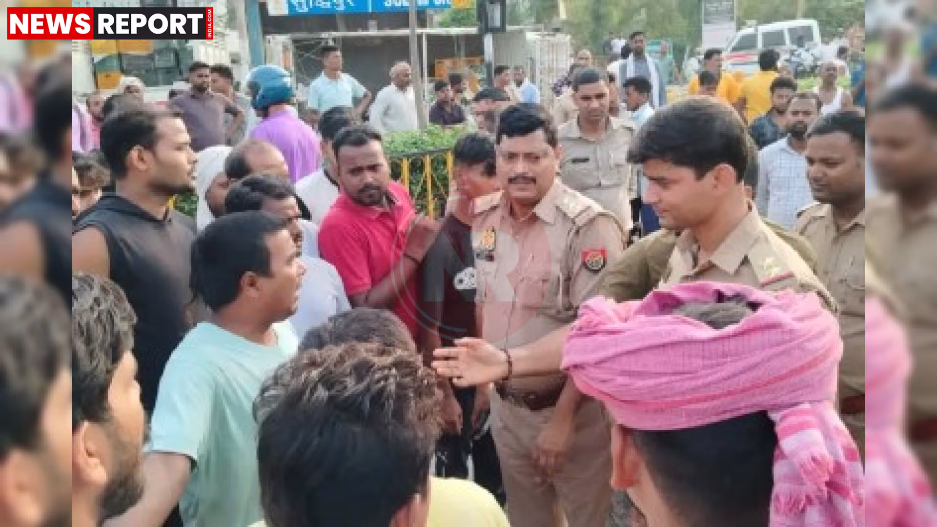 एक व्यस्त हाईवे पर क्षतिग्रस्त ट्रक और पुलिसकर्मियों के साथ आक्रोशित ग्रामीणों की भीड़