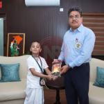 छह वर्षीय भक्त भागवत प्रभु जी प्रवचन करते हुए, उनके चारों ओर श्रद्धालु बैठे हैं।