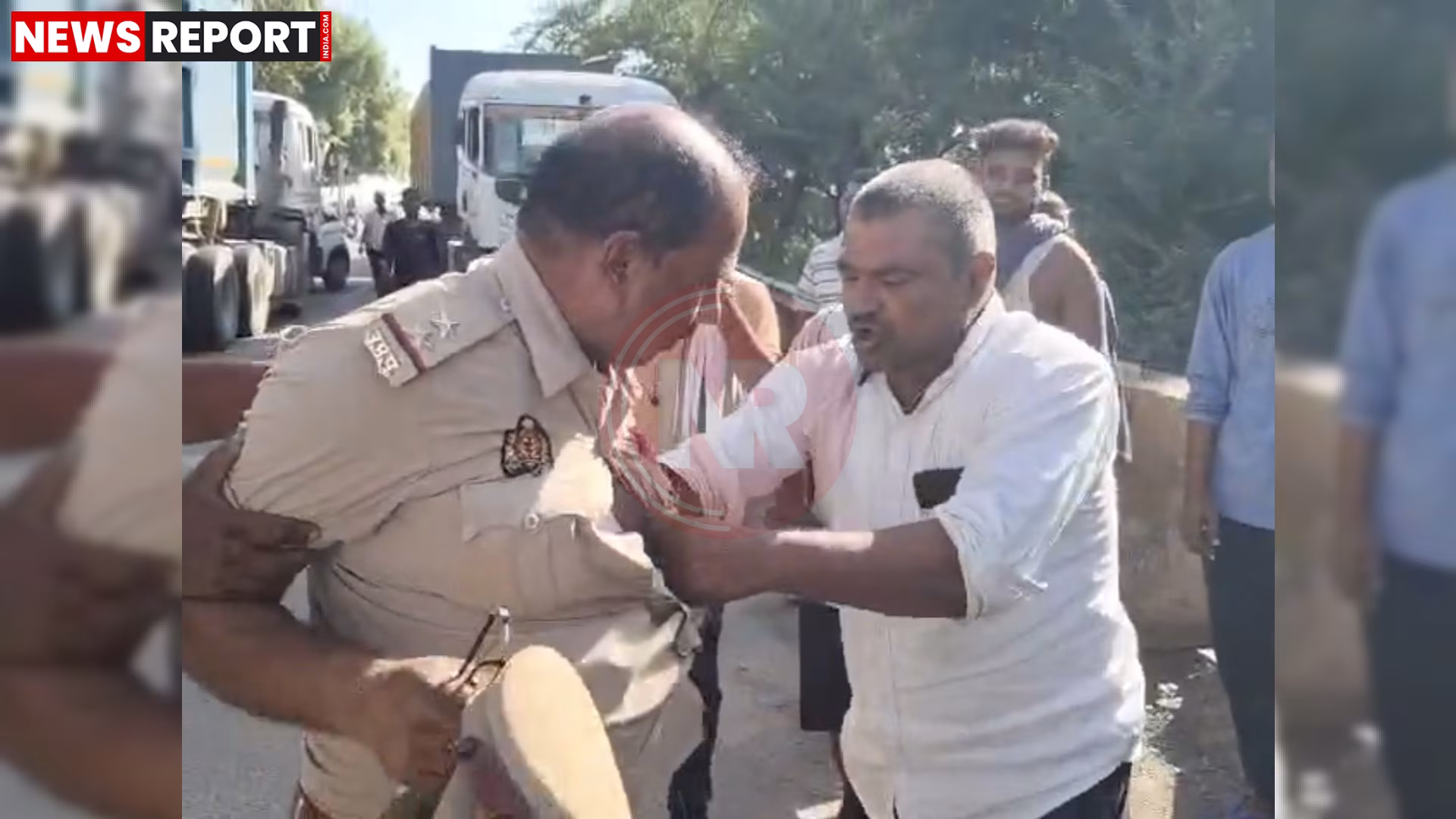 हमीरपुर में ट्रक चालक द्वारा दरोगा की बीच सड़क पर पिटाई करते हुए, लोग बीच-बचाव कर रहे हैं।