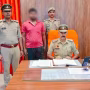 पुलिस हिरासत में एक अपराधी, पीछे पुलिसकर्मी खड़े हैं।