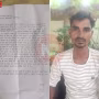 एक घायल टोटो चालक पुलिस को शिकायत पत्र देते हुए, पीछे पुलिस स्टेशन और एक टोटो दिख रहा है।