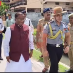 राज्यपाल लक्ष्मण प्रसाद आचार्य अपनी बहन से राखी बंधवाते हुए, बगल में सुरक्षाकर्मी।