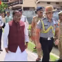 राज्यपाल लक्ष्मण प्रसाद आचार्य अपनी बहन से राखी बंधवाते हुए, बगल में सुरक्षाकर्मी।
