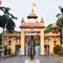 काशी हिंदू विश्वविद्यालय (BHU) का मुख्य द्वार और उस पर निलंबन आदेश की प्रतिलिपि पकड़े एक छात्र की सांकेतिक तस्वीर।