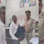 एक पुलिस अधिकारी एक व्यक्ति को नकदी से भरा बैग लौटाते हुए, खुशी का माहौल