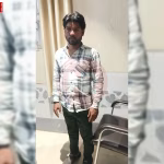 एक व्यक्ति को रिश्वत लेते हुए एंटी करप्शन टीम द्वारा गिरफ्तार किया जा रहा है, उसके हाथ में नोटों का बंडल है।