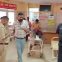 वाराणसी में चीनी मांझे से गला कटा हुआ व्यक्ति सड़क पर गिरा हुआ, आसपास भीड़।